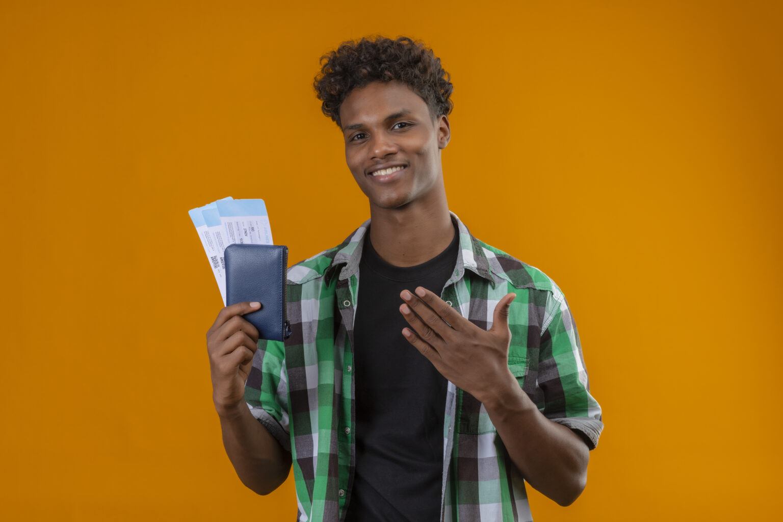 Direito do trabalho: A imagem mostra um jovem sorridente segurando uma carteira de trabalho azul diante de um fundo laranja vibrante. Ele transmite entusiasmo e orgulho, sugerindo que acaba de conquistar um novo emprego ou uma oportunidade profissional importante. A composição colorida e o tom positivo da foto fazem dela uma excelente escolha para ilustrar temas como início de carreira, primeiro emprego, conquista profissional, valorização do trabalho formal e direitos garantidos pela CLT.