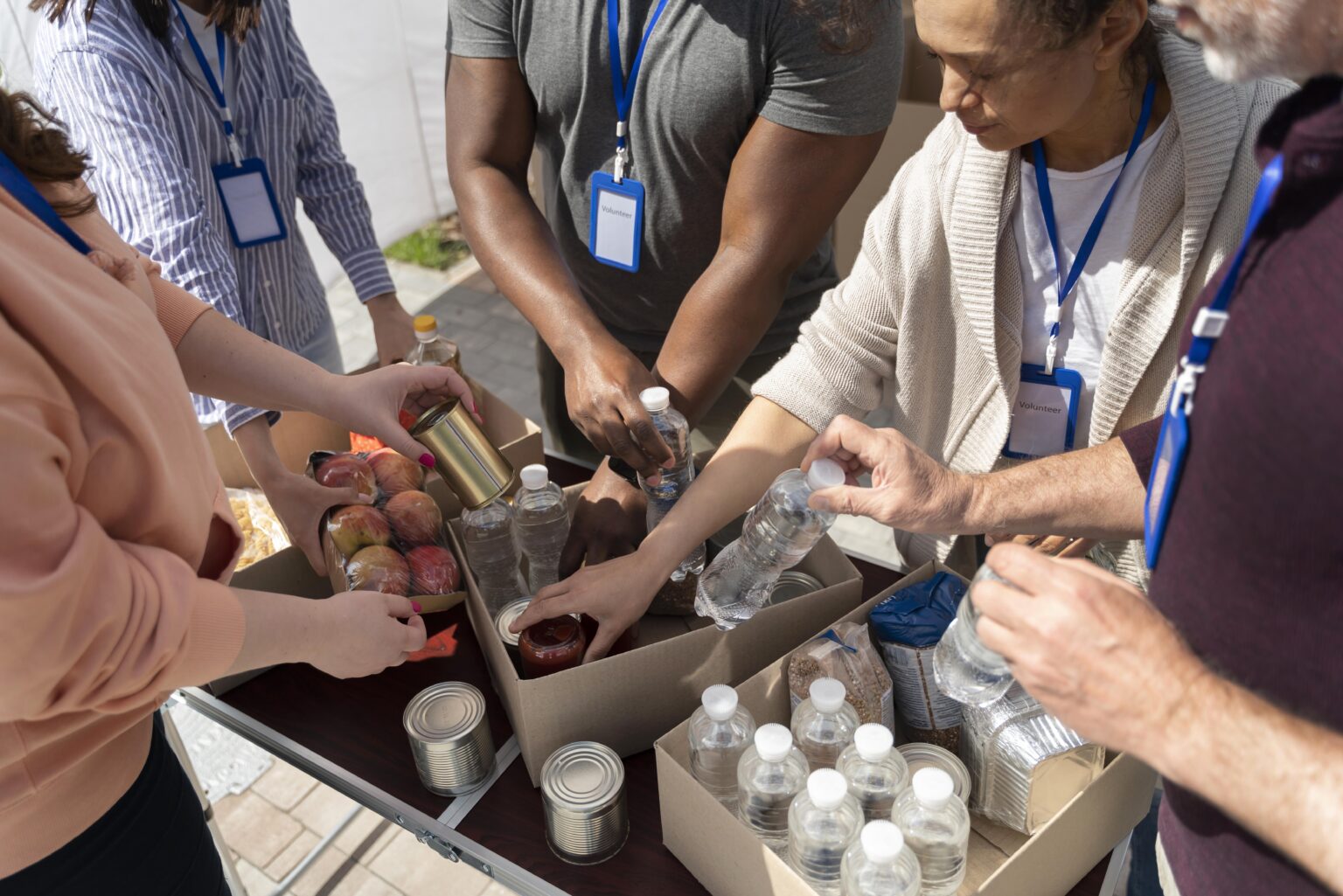 terceiro setor: A imagem mostra voluntários organizando caixas com alimentos e garrafas de água, representando a atuação solidária e colaborativa típica do Terceiro Setor no apoio a comunidades e causas sociais.